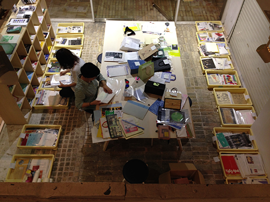 『山下さんちの資料(アーカイブ)を持って帰る展』の準備風景。段ボールに詰め込まれた資料を年代別に分類していく。90年代の関西アートシーンの一端が浮かび上がってくる。