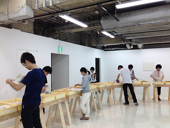 『山下さんちの資料(アーカイブ)を持って帰る展』の会場風景より。アーティストの藤本由紀夫の空間構成で、「パン箱」に年代ごとの資料をいれて配置した。1980〜1990年代を実体験した人たちだけでなく、その頃に生まれた若者たちが熱心に資料を取り出してはコピーをしていった。